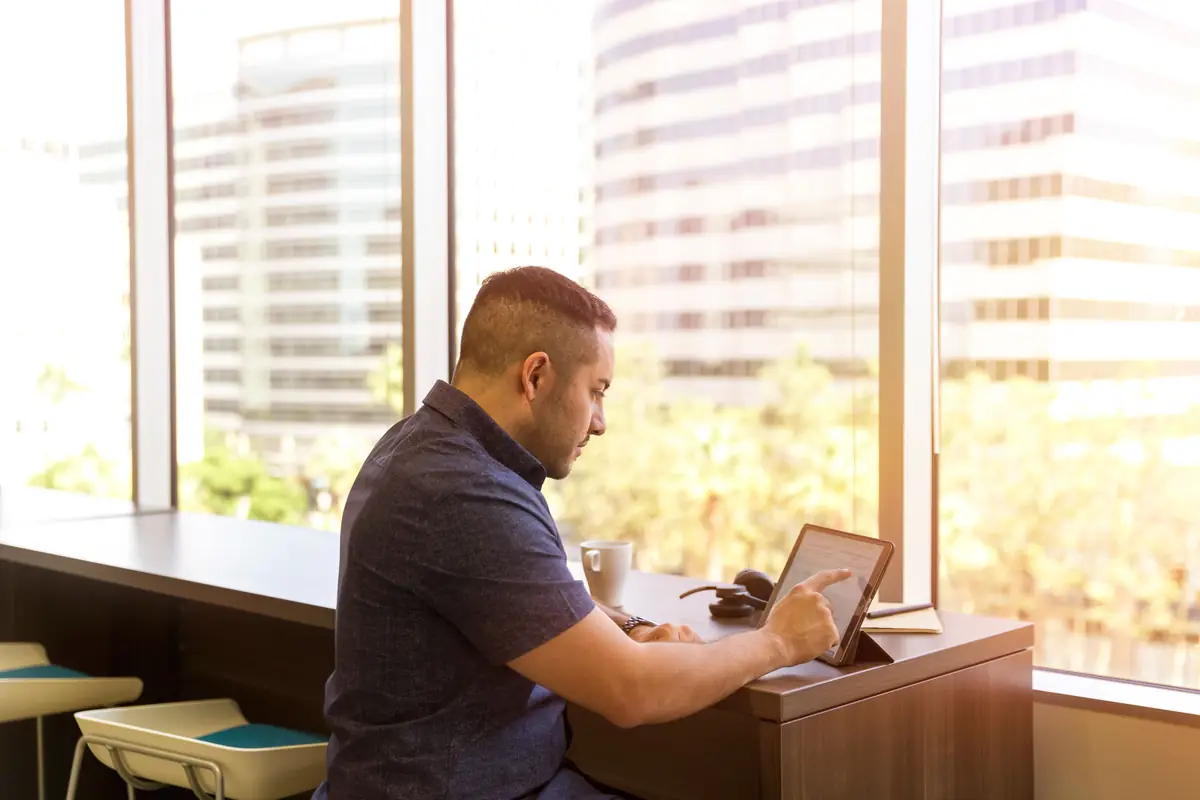 A property manager working on a tablet by an office window