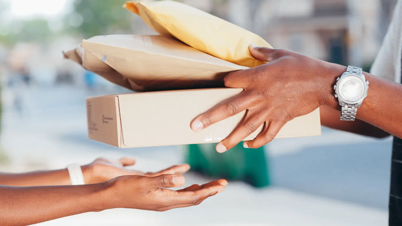A courier handing a parcel to a customer