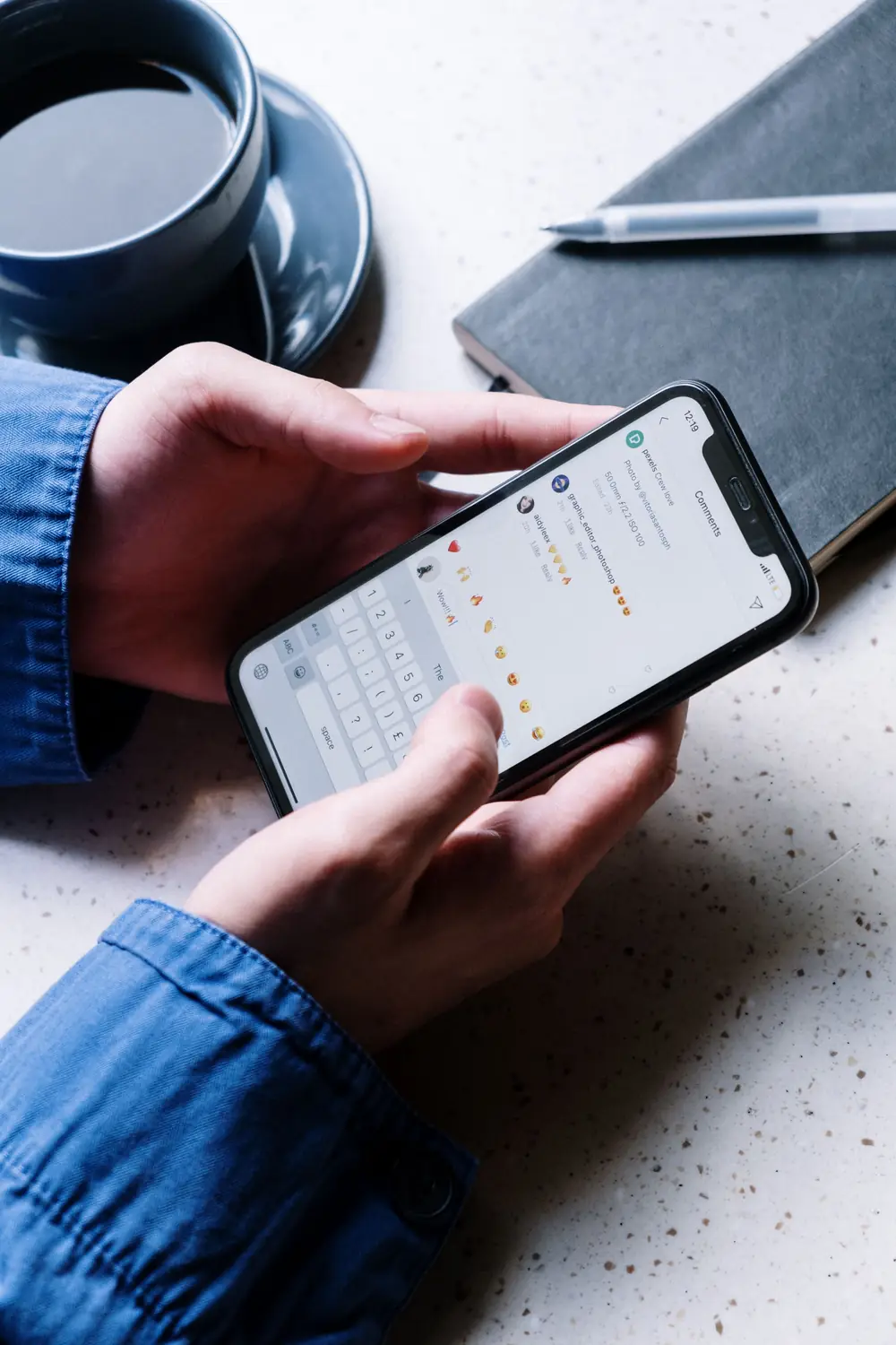 Hands holding a phone with a list of messages